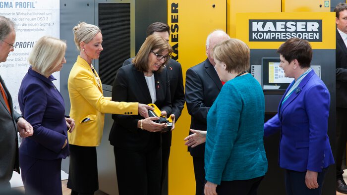Frau Vlantoussi-Kaeser überreicht der Bundeskanzlerin Angela Merkel das Modell eines Kompressors.