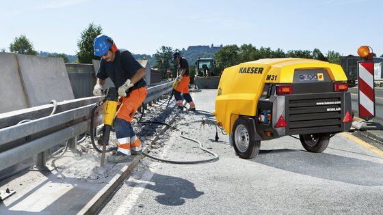 Abrissarbeiten an der Autobahn mit KAESER Mobilair M31 – der mobile Kompressor versorgt pneumatisches Werkzeug zuverlässig mit Druckluft.