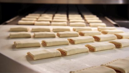Das charakteristische Schinken-Käse-Gebäck von Panike auf der Fertigungslinie.